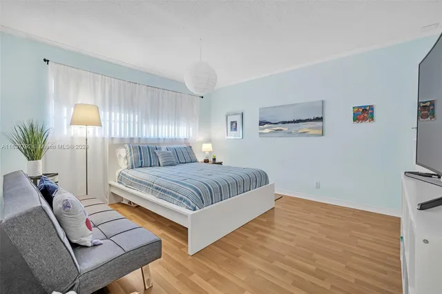 a bedroom with a large bed and a potted plant