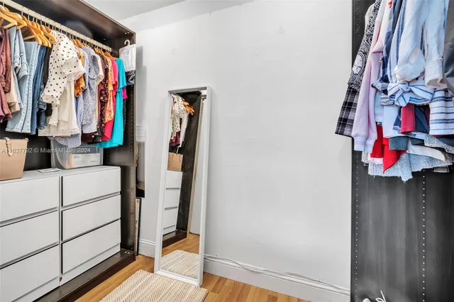 a view of walk in closet with clothes and shoes