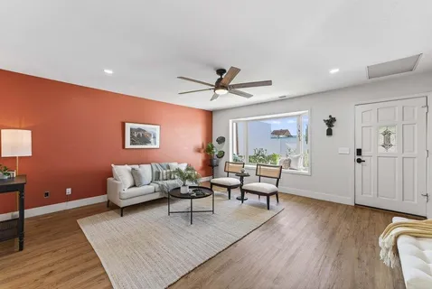 a kitchen with stainless steel appliances granite countertop a dining table chairs a sink a refrigerator and microwave