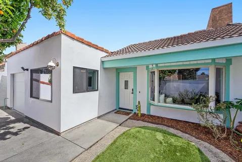 a view of a house with a yard and potted plants