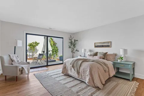 a bedroom with a bed and wooden floor