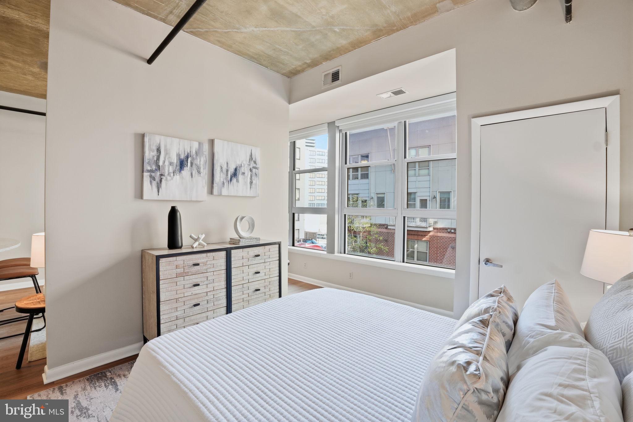 1300 N Street Northwest, Unit 207 Washington, DC 20005 - Photo 14 of 24 a bedroom with a bed and a window