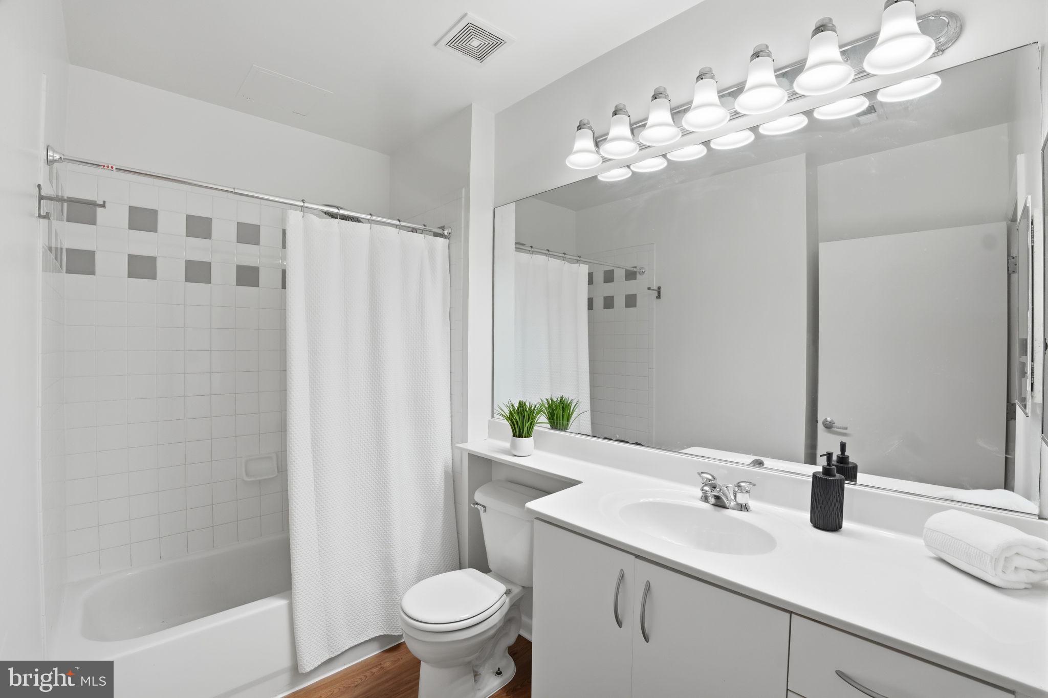 1300 N Street Northwest, Unit 207 Washington, DC 20005 - Photo 17 of 24 a bathroom with a granite countertop sink a toilet and a mirror