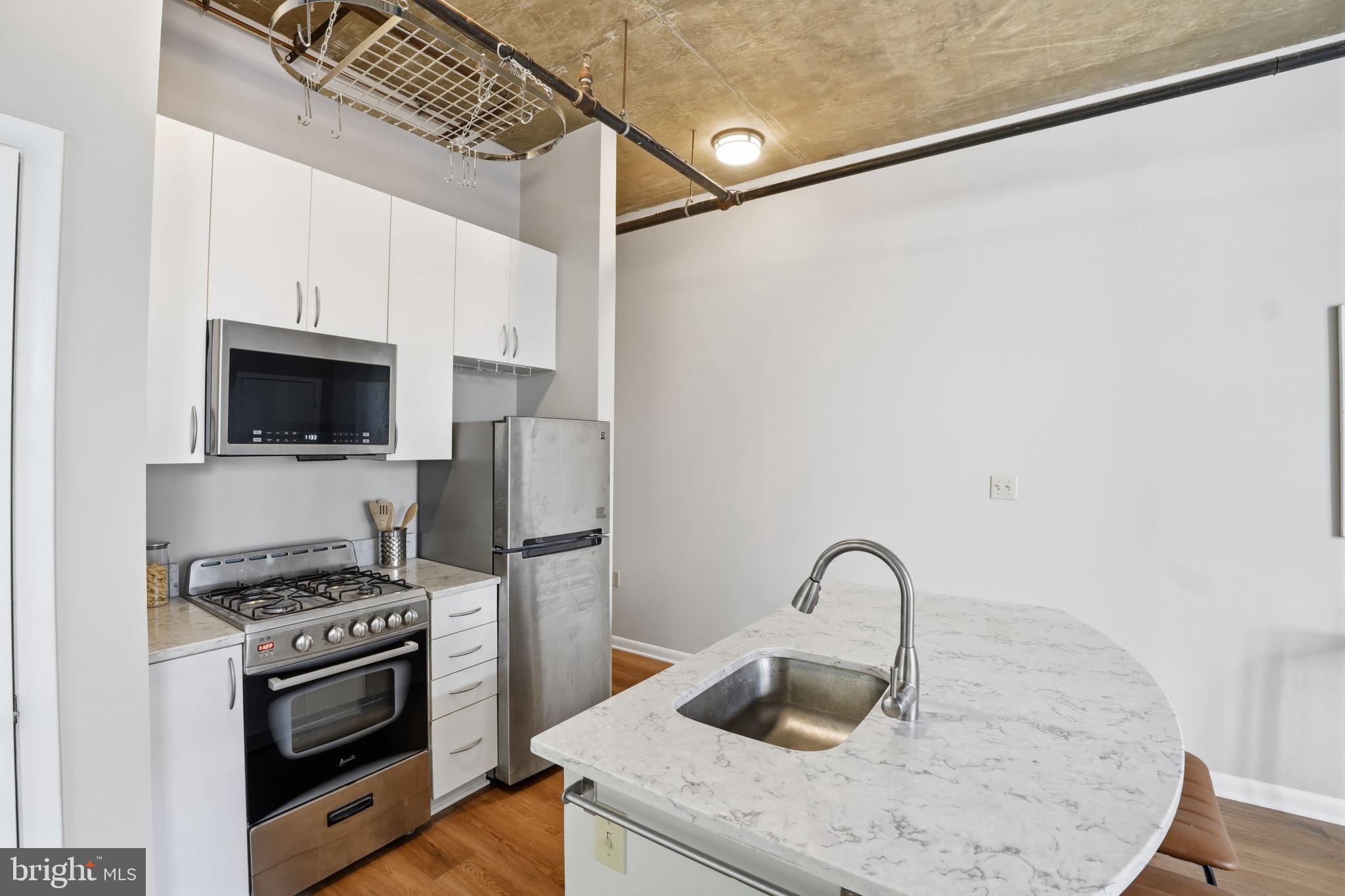1300 N Street Northwest, Unit 207 Washington, DC 20005 - Photo 8 of 24 a kitchen with a appliances and a stove top oven