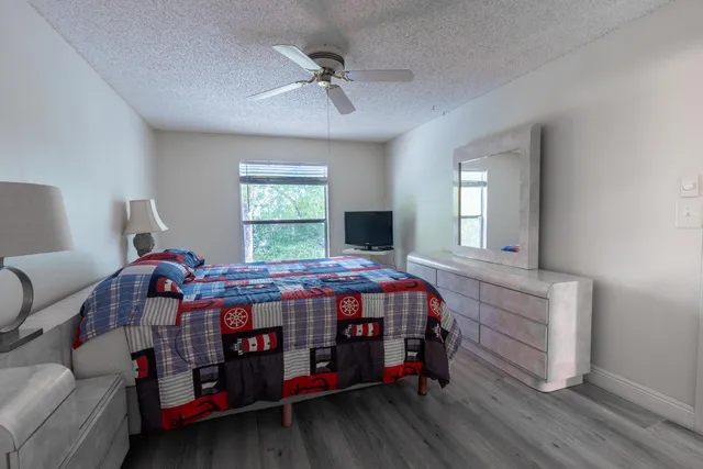 a bedroom with a bed window and a dresser