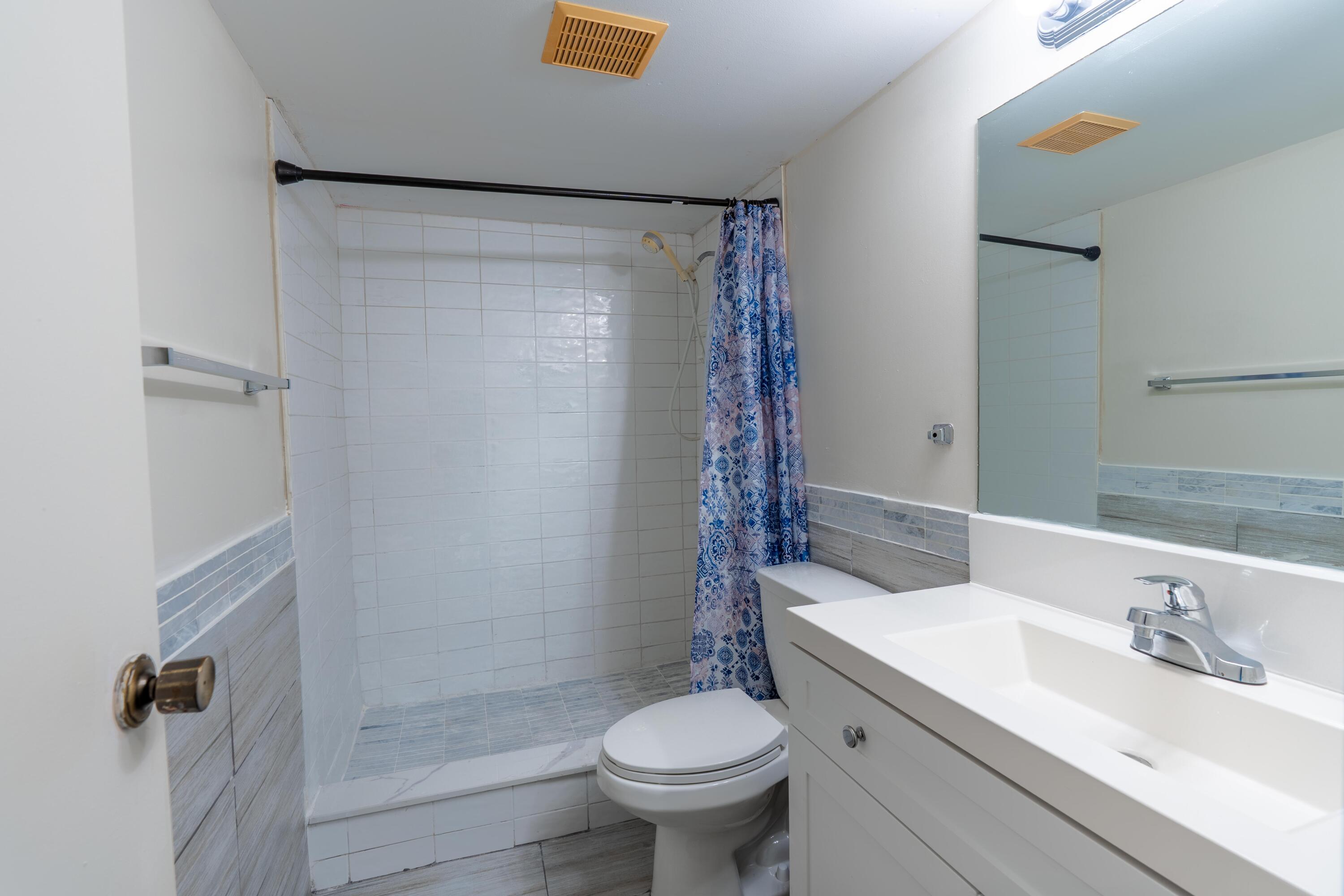 8360 Sands Point Boulevard, Unit G306 Tamarac, FL 33321 - Photo 10 of 13 a bathroom with a sink toilet and shower