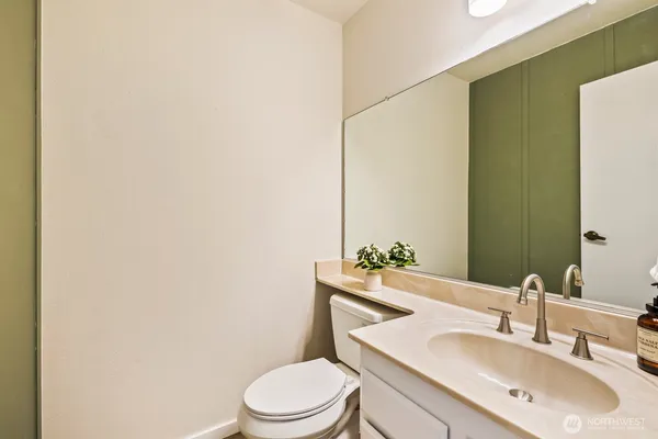 a bathroom with a toilet a sink and mirror