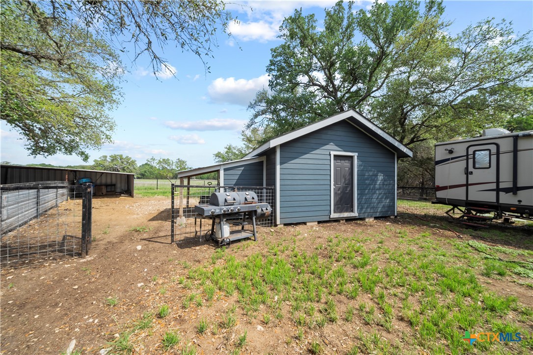 351 Line Camp Loop Spring Branch, TX 78070 - Photo 19 of 27 a view of a backyard with table and chairs a barbeque and a large tree