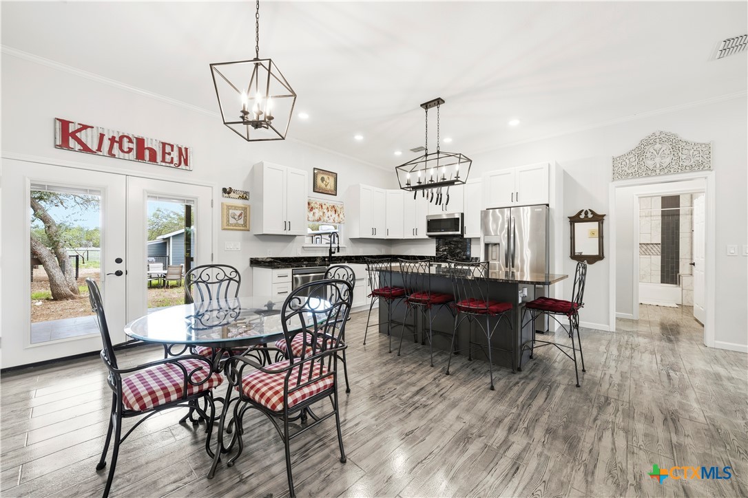 351 Line Camp Loop Spring Branch, TX 78070 - Photo 7 of 27 a view of a dining room with furniture wooden floor and chandelier