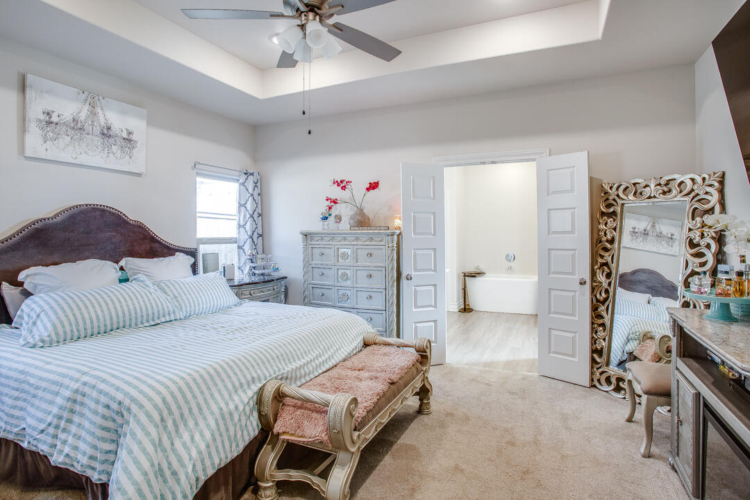 5701 119th Street Lubbock, TX 79424 - Photo 11 of 22 a bedroom with a bed and a chandelier