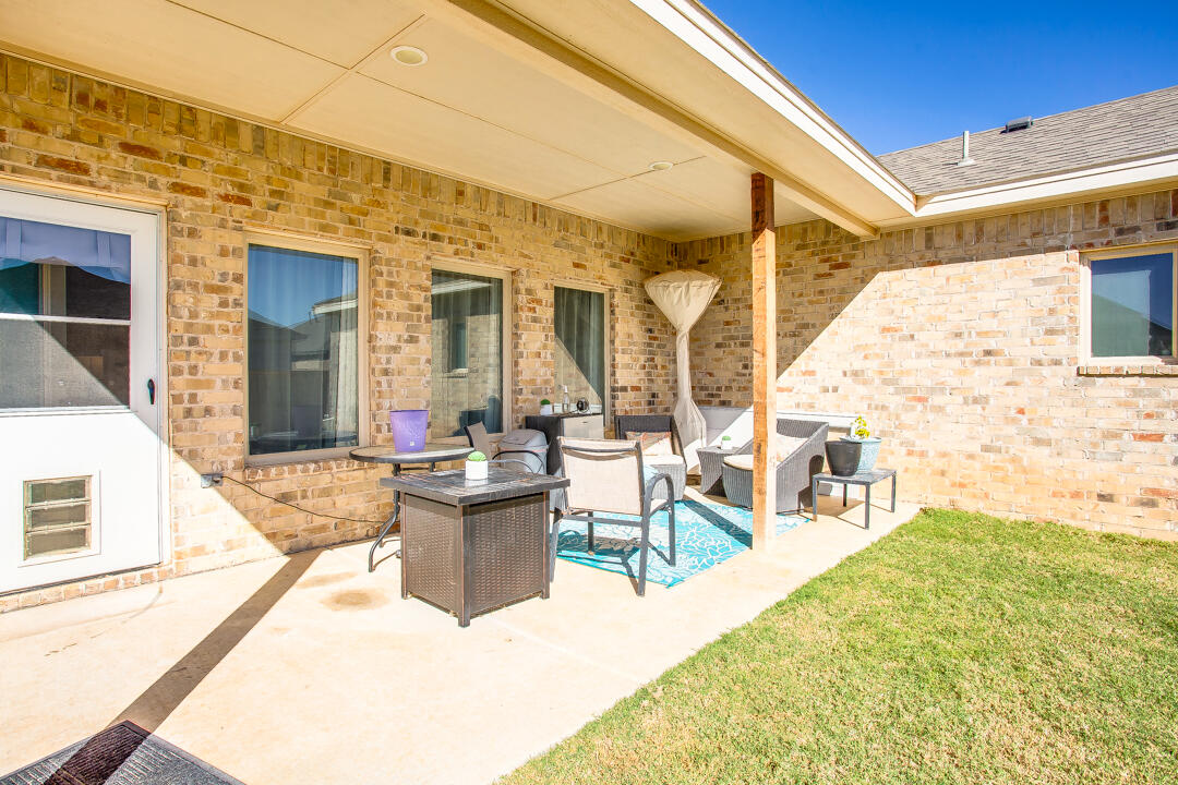 5701 119th Street Lubbock, TX 79424 - Photo 21 of 22 a view of a patio with couches chairs and floor to ceiling window with wooden floor