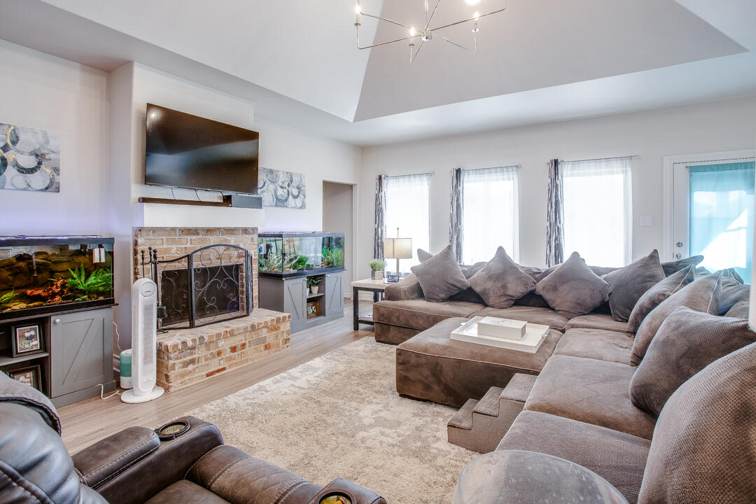 5701 119th Street Lubbock, TX 79424 - Photo 4 of 22 a living room with furniture a flat screen tv and a fireplace