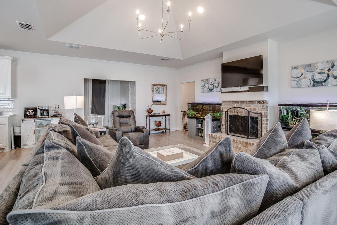 5701 119th Street Lubbock, TX 79424 - Photo 5 of 22 a living room with furniture a fireplace and a flat screen tv