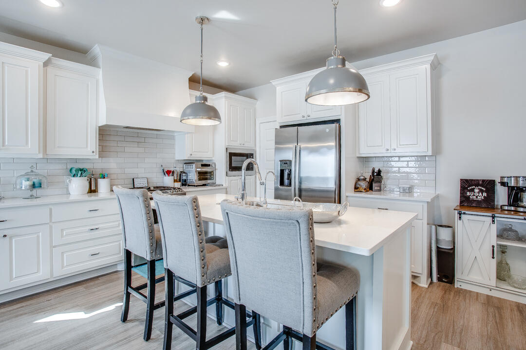 5701 119th Street Lubbock, TX 79424 - Photo 7 of 22 a kitchen with stainless steel appliances a dining table chairs and white cabinets