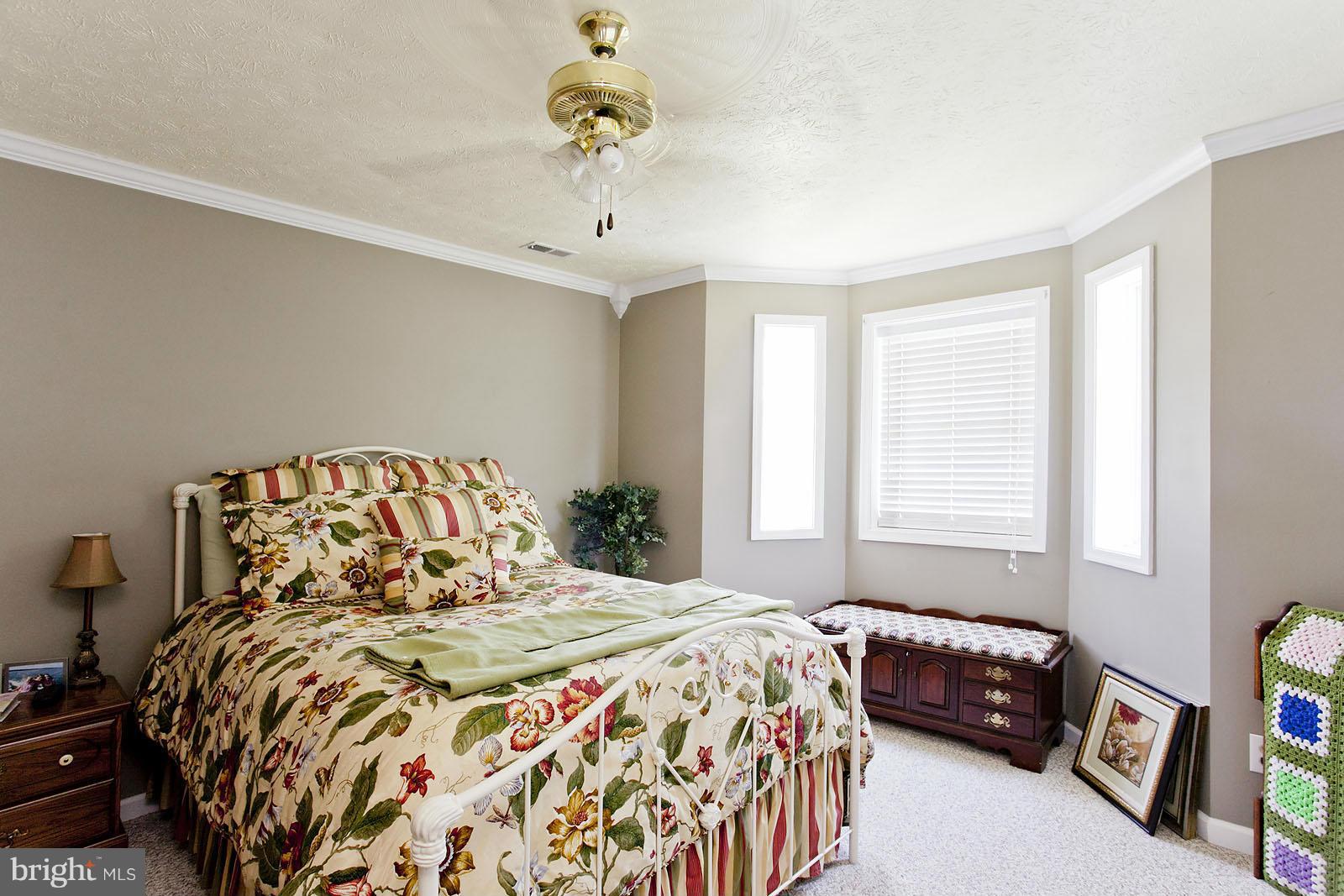 1209 Hollow Road Gore, VA 22637 - Photo 17 of 30 a bedroom with a large bed and a chandelier