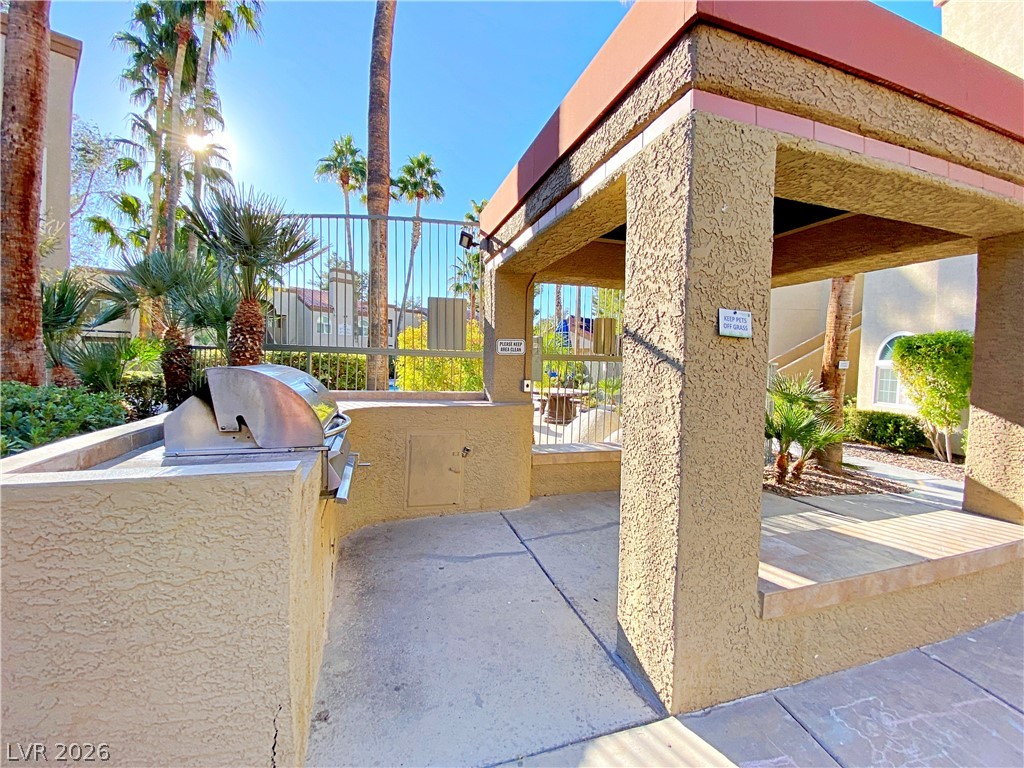 3145 East Flamingo Road, Unit 1128 Las Vegas, NV 89121 - Photo 19 of 19 An inviting outdoor cooking area awaits, nestled among lush palms and offering a convenient space for gatherings.