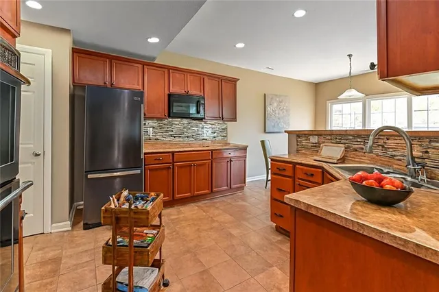 a kitchen with stainless steel appliances granite countertop a refrigerator and a sink