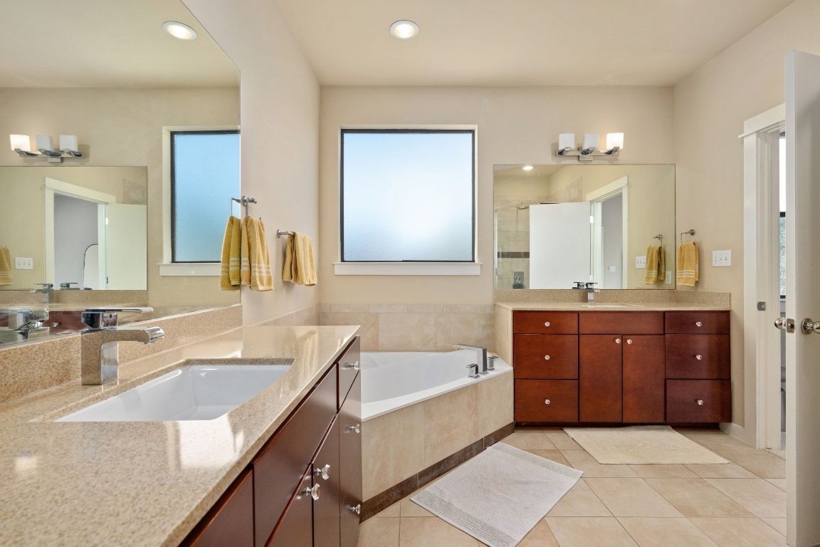 2819 Corbin Lane Austin, TX 78704 - Photo 14 of 22 a bathroom with a granite countertop double vanity sink a bathtub and mirror