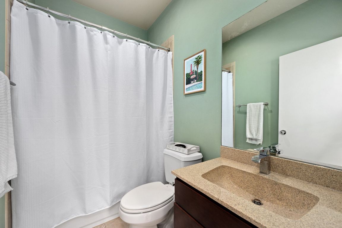 2819 Corbin Lane Austin, TX 78704 - Photo 17 of 22 a bathroom with a granite countertop sink toilet and a mirror