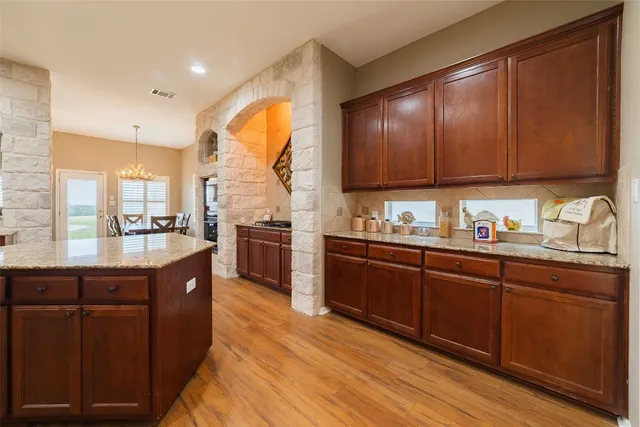a kitchen with stainless steel appliances granite countertop a stove a sink and a microwave