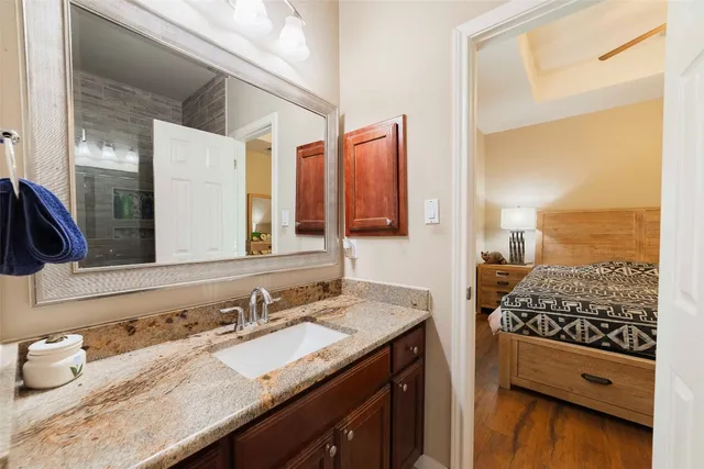 a bathroom with a granite countertop sink a bathtub and shower