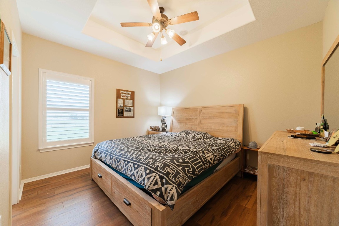 20145 Janak Road Coupland, TX 78615 - Photo 26 of 40 a bed sitting in a bedroom next to a window with a chandelier