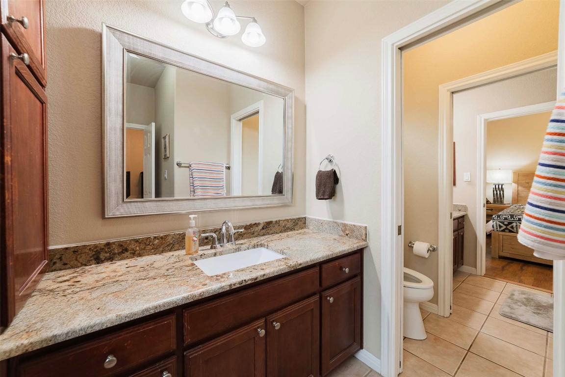 20145 Janak Road Coupland, TX 78615 - Photo 30 of 40 a bathroom with a granite countertop sink and a mirror