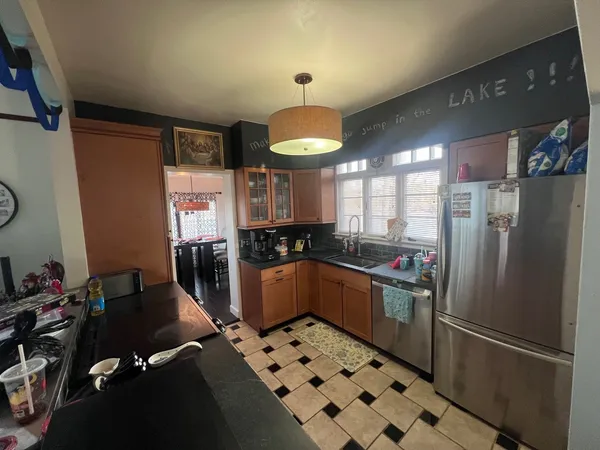 a kitchen with granite countertop a refrigerator and a sink