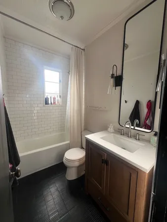 a bathroom with a sink toilet a mirror and shower