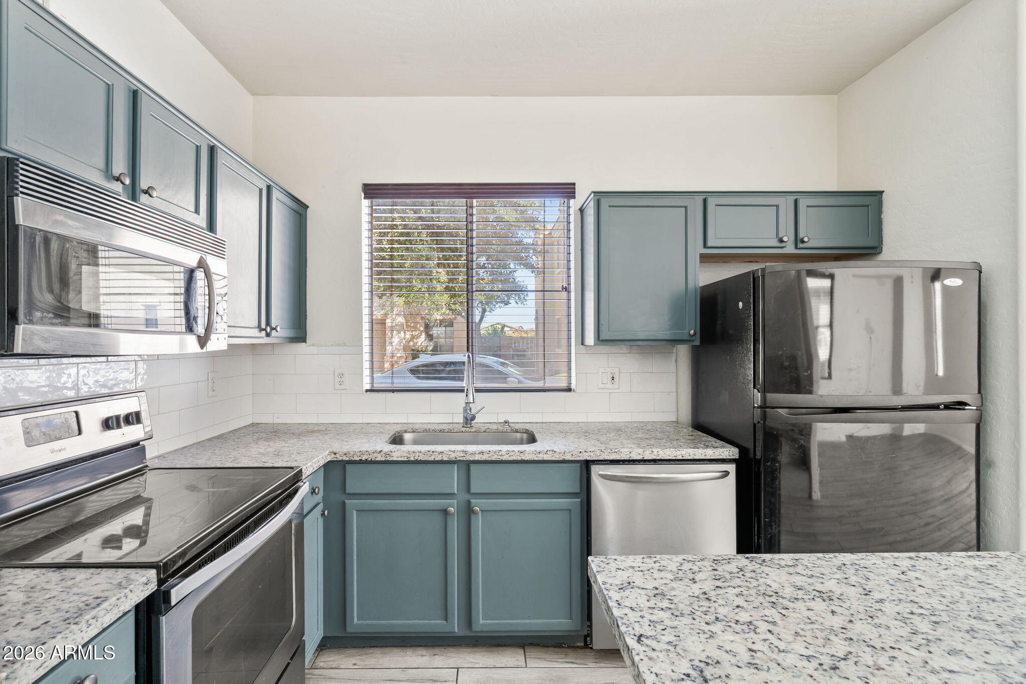 1332 East Dunbar Drive Phoenix, AZ 85042 - Photo 11 of 50 a kitchen with kitchen island granite countertop a sink stove and refrigerator