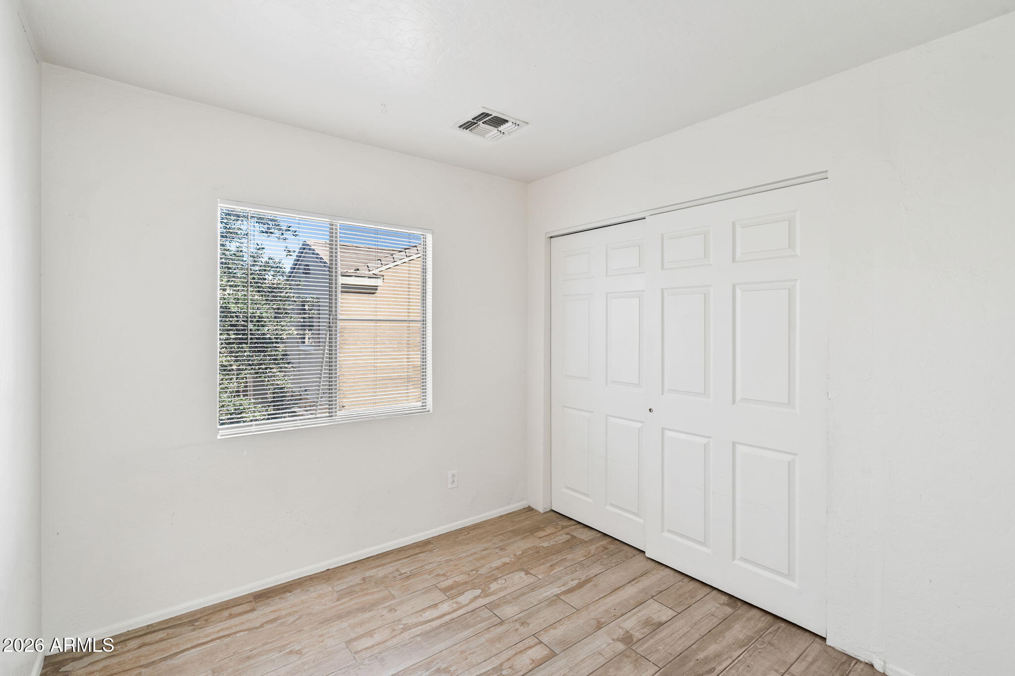 1332 East Dunbar Drive Phoenix, AZ 85042 - Photo 16 of 50 an empty room with wooden floor and windows