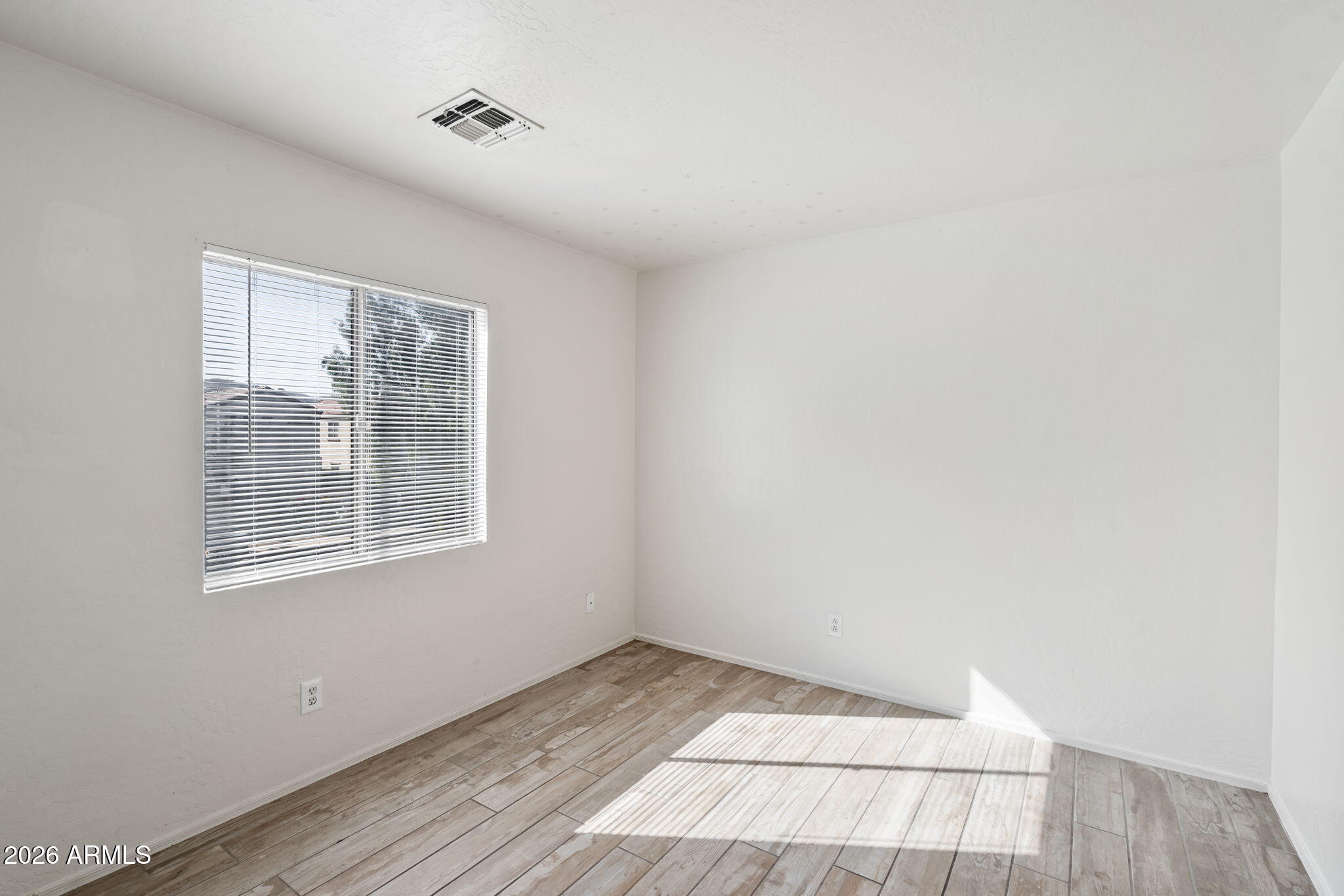 1332 East Dunbar Drive Phoenix, AZ 85042 - Photo 20 of 50 a view of an empty room with wooden floor and a window