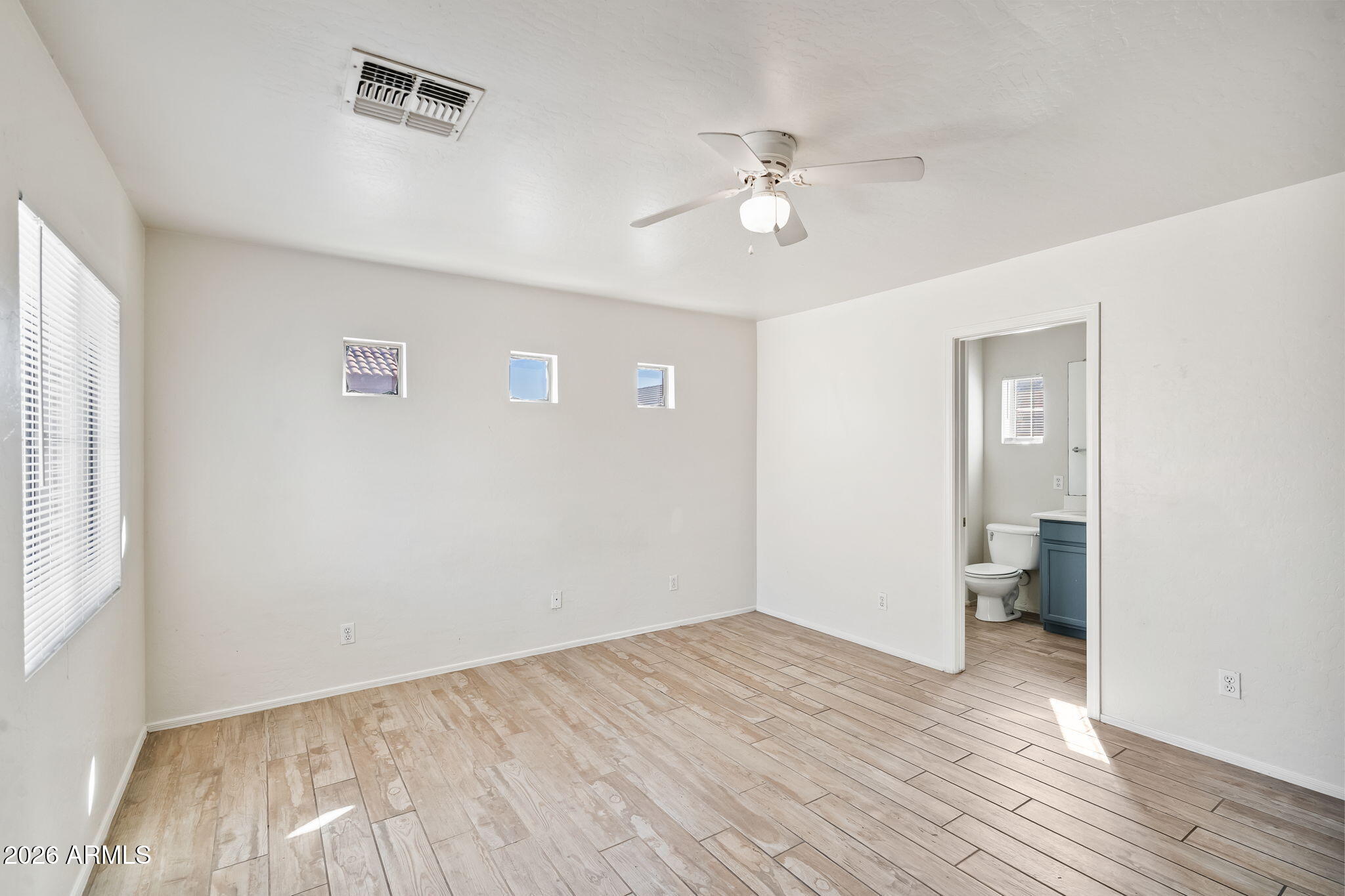 1332 East Dunbar Drive Phoenix, AZ 85042 - Photo 24 of 50 a view of an empty room with wooden floor and a window