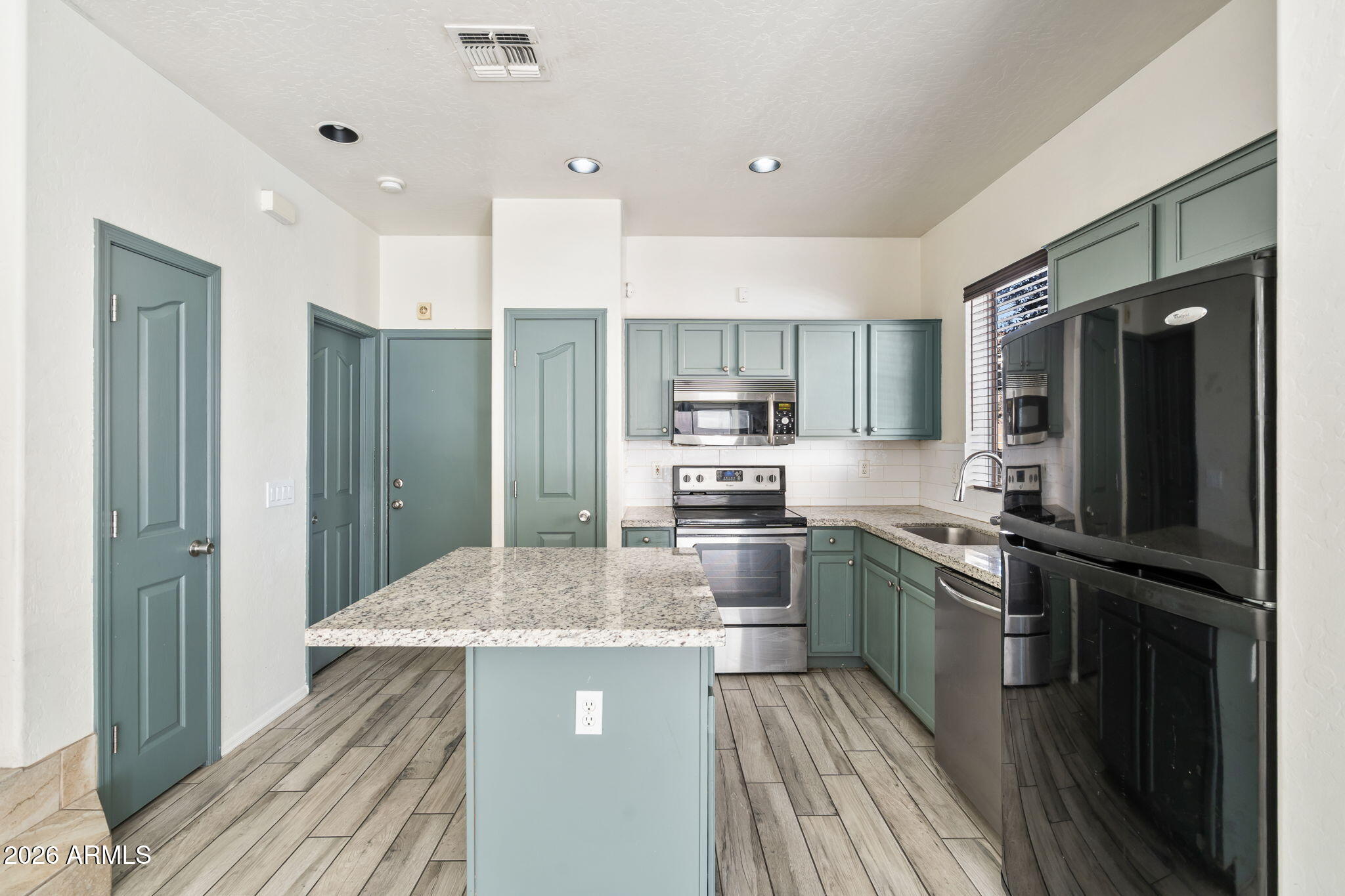 1332 East Dunbar Drive Phoenix, AZ 85042 - Photo 9 of 50 a kitchen with kitchen island granite countertop stainless steel appliances a refrigerator stove top oven and sink