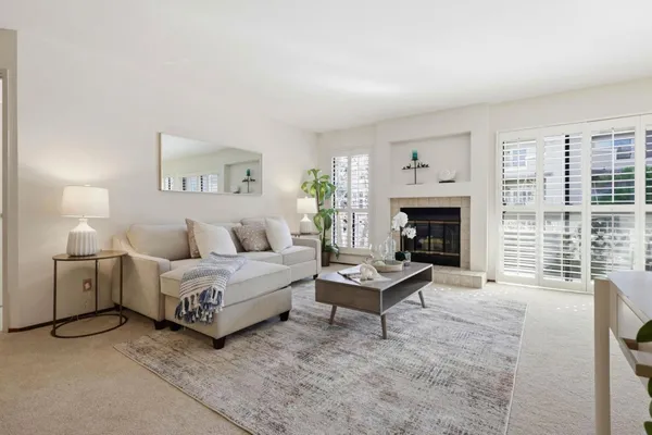 a living room with furniture a fireplace and a table