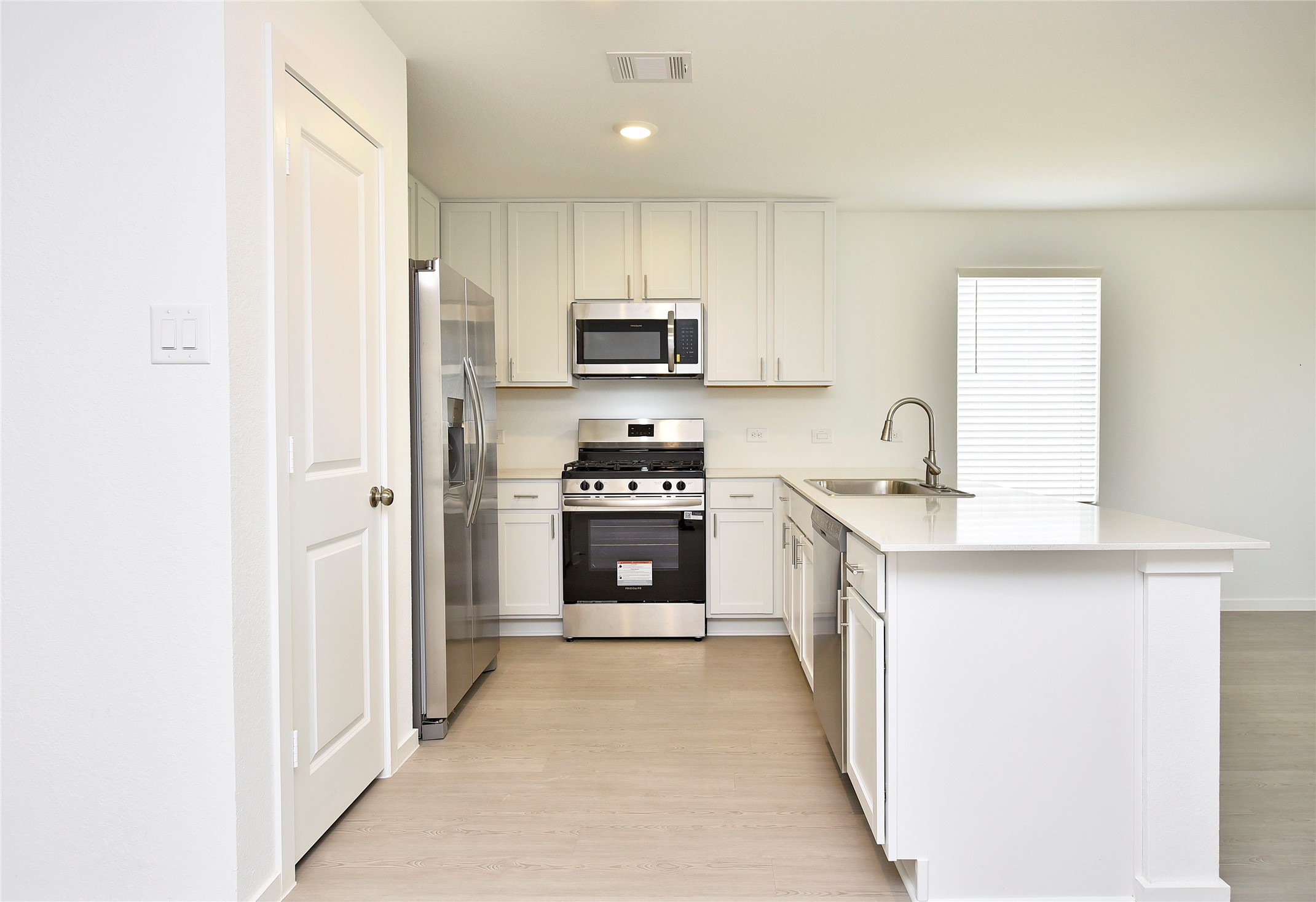 10218 Prairie Dunes Lane Cleveland, TX 77327 - Photo 11 of 32 a kitchen with stainless steel appliances a stove sink and refrigerator