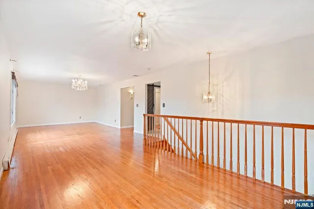 a view of a livingroom with wooden floor and pendant lights