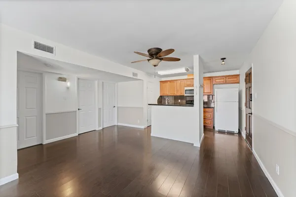 a view of a kitchen with wooden floor and electronic appliances