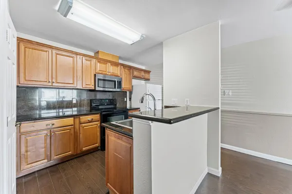 a kitchen with stainless steel appliances granite countertop a stove a sink and a microwave