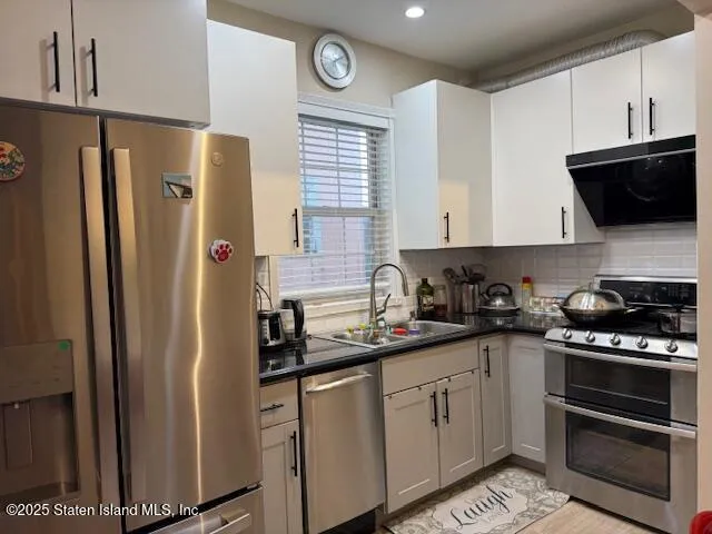 a living room with furniture a flat screen tv and a refrigerator