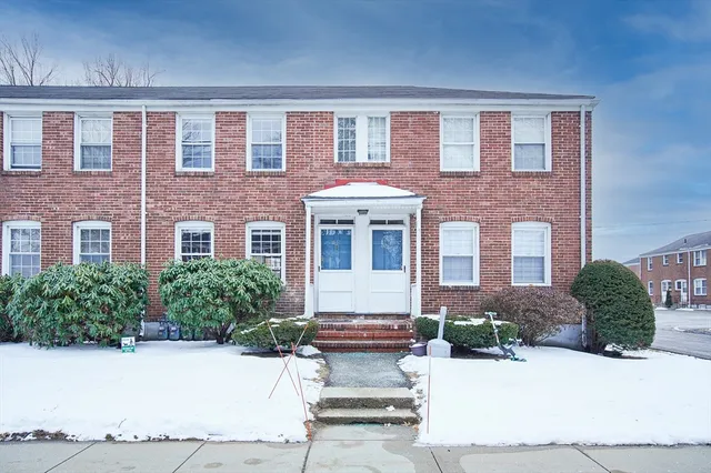 front view of a brick house with a yard