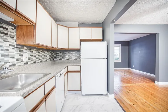 a kitchen with a refrigerator sink and cabinets