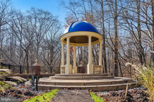 a front view of a house with garden and trees