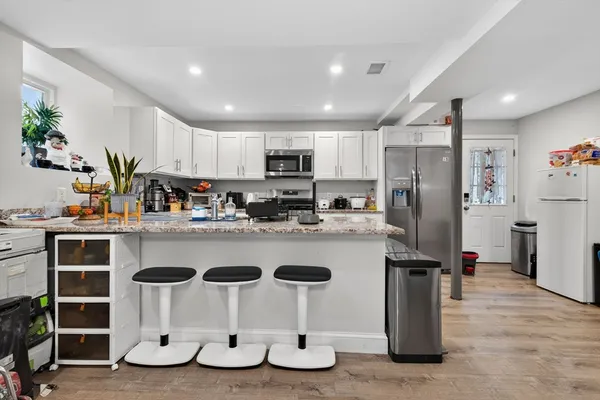 a kitchen with kitchen island granite countertop a refrigerator and a sink