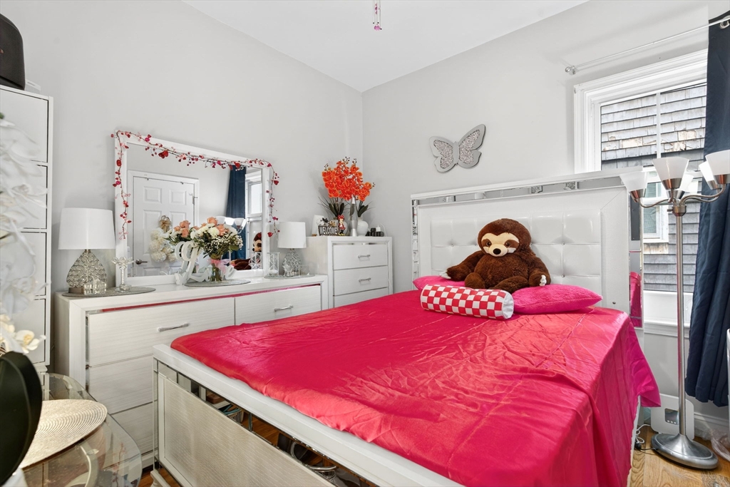 1684 North Shore Road Revere, MA 02151 - Photo 12 of 39 a bedroom with a bed and a potted plant on dresser