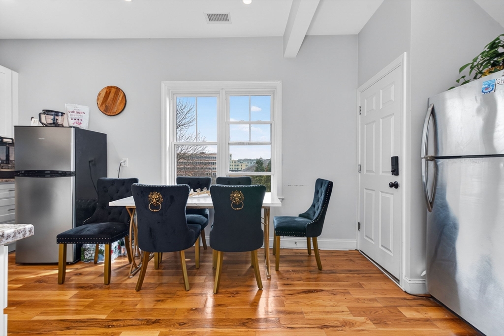 1684 North Shore Road Revere, MA 02151 - Photo 24 of 39 a dining room with furniture a rug a potted plant and wooden floor