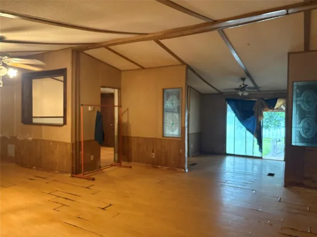 a view of a big room with wooden floor and windows