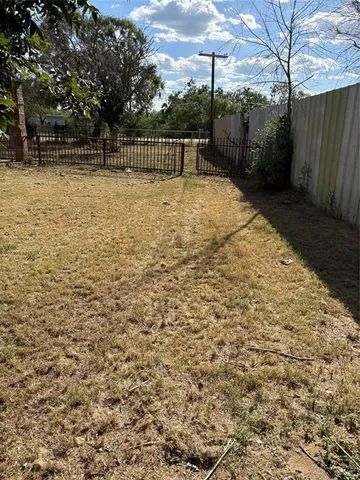 a view of backyard with wooden fence