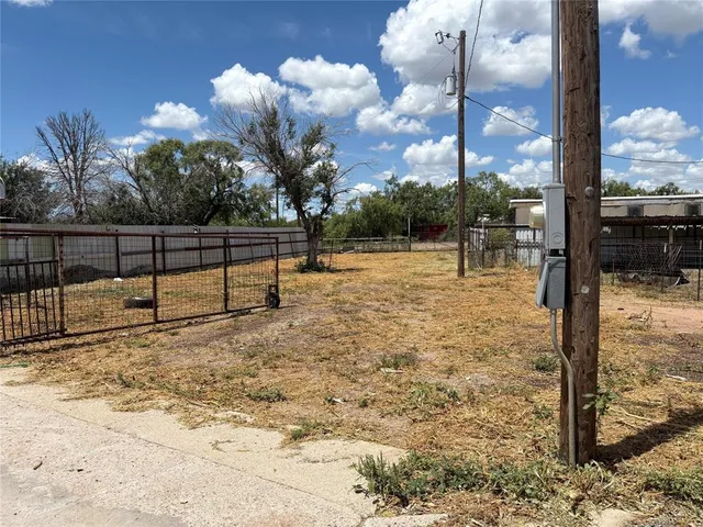 a view of a yard with wooden fence