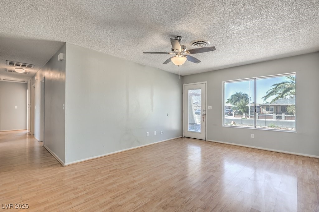 3948 Maple Hill Road Las Vegas, NV 89115 - Photo 5 of 20 Spare room with visible vents, a textured ceiling, light wood finished floors, and a ceiling fan